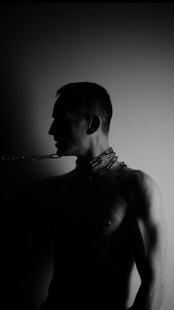 Profil im Schatten, eine Kette um den Hals.