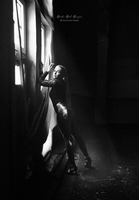 Sarah in Spitze am Fenster mit Vorhang, der Blick in die Kamera.