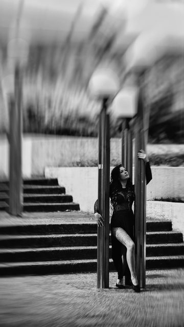 Celine in Schwarz an einer Laterne vor einer breiten Treppe.
